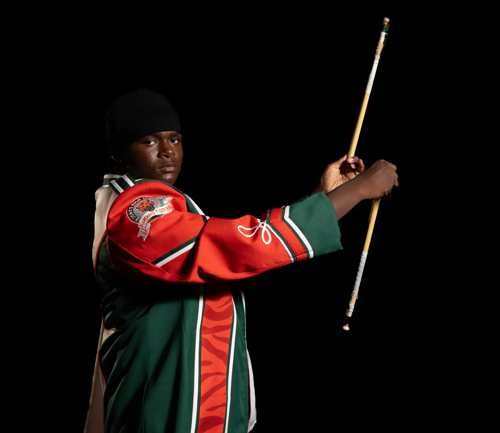 Jones High band member posing with a mace during Media Day