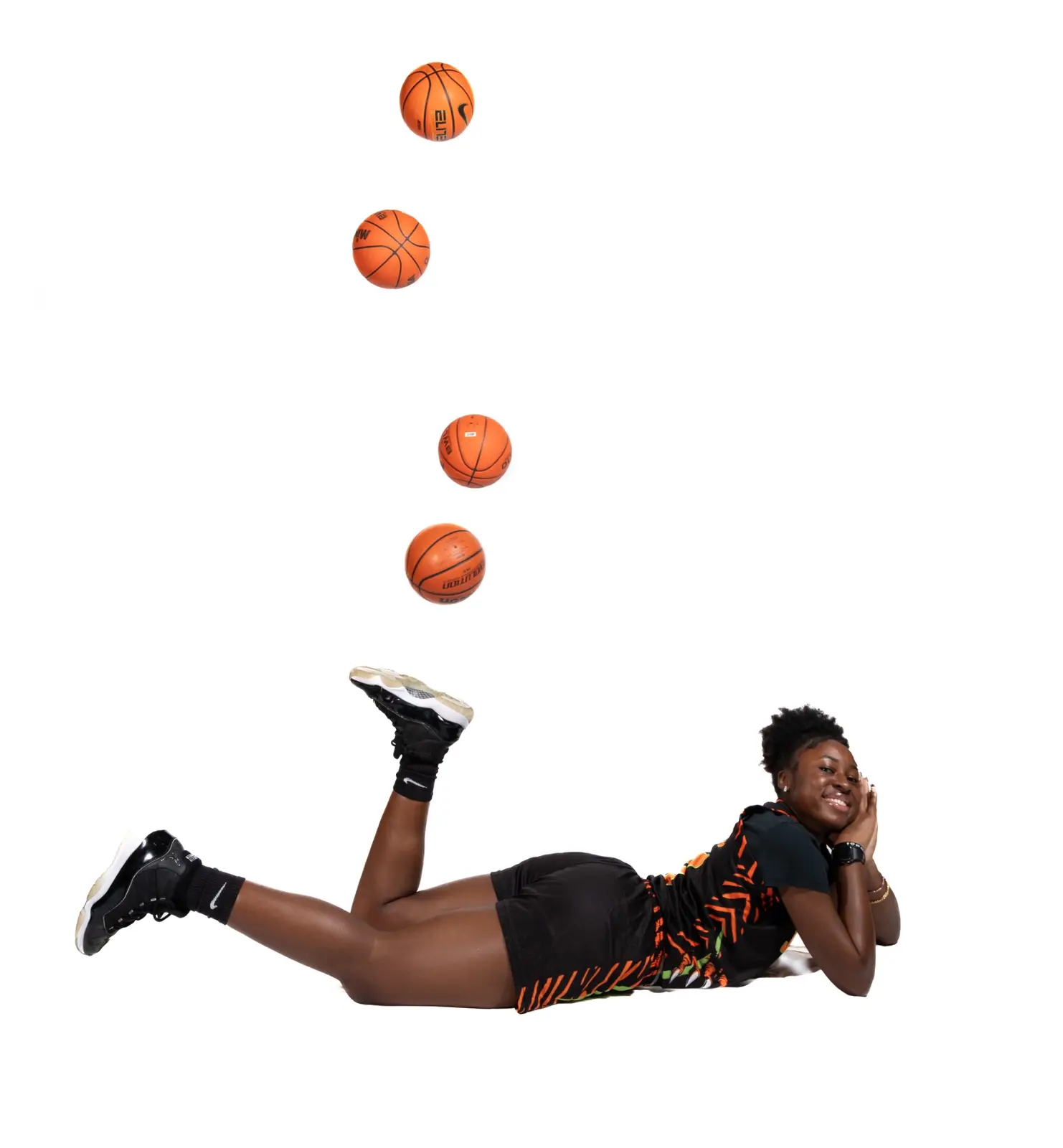 Jones High basketball athlete posing beneath a sequence of basketballs